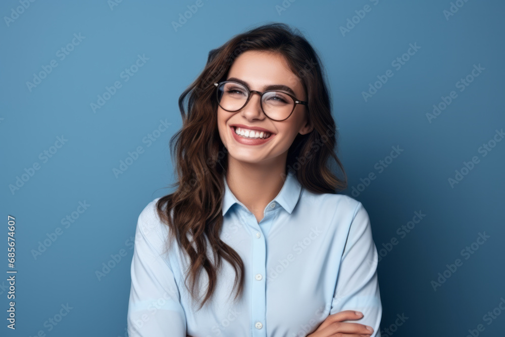 Portrait of happy young businesswoman in eyeglasses on blue background Portrait of happy young businesswoman in eyeglasses on blue background