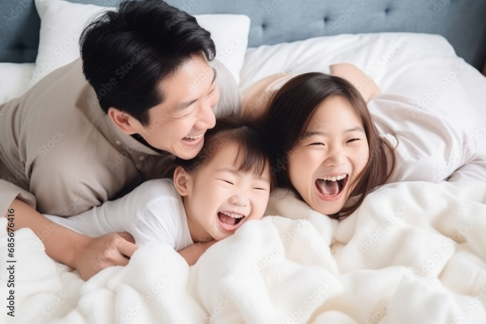 Happy asian family lying in bed and laughing together at home. Happy asian family lying in bed and laughing together at home.