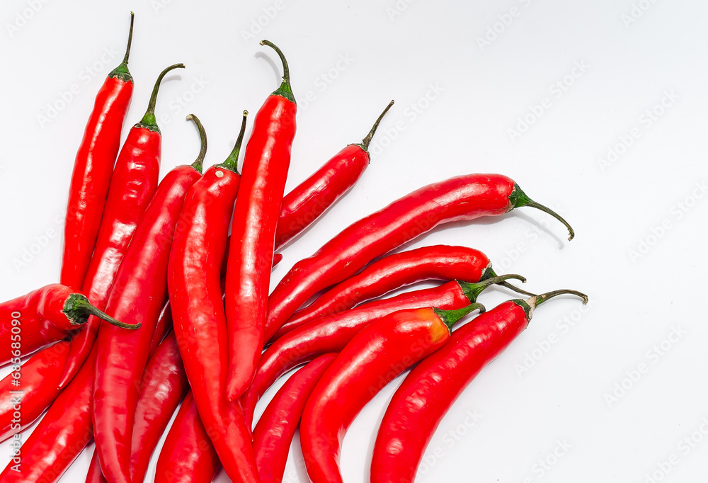 Close up bunch of red chili peppers on white isolated background. Diagonally in lower left corner.