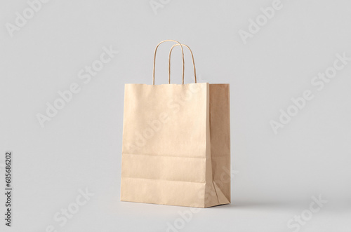 Kraft paper bag with handles, blank mockup isolated on a grey background. photo