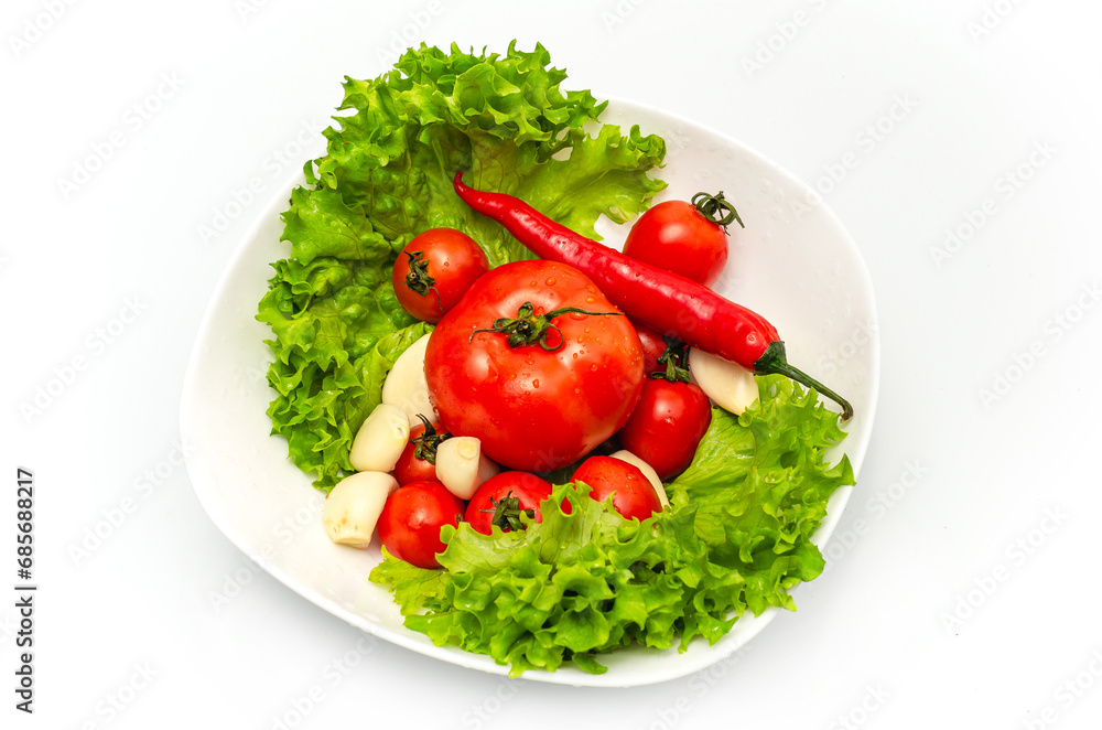 Delicious vegetable salad in a bowl with water drops. Tomatoes, lettuce, garlic, chili. Delicious vegetable salad in a bowl with water drops. Tomatoes, lettuce, garlic, chili.
