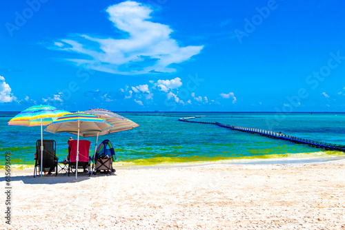 Tropical Caribbean beach people parasols fun Playa del Carmen Mexico. photo