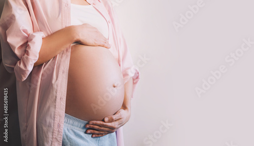 Closeup beautiful pregnant woman belly with her hands. Pregnancy, maternity, preparation and expectation concept. photo