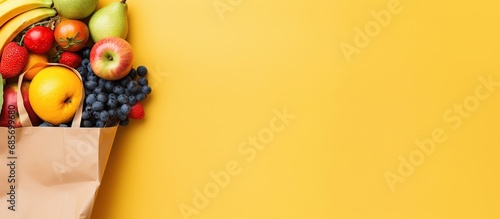 Fresh fruits group on a brown paper bag isolated yellow background. photo
