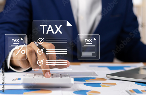 Tax and Vat concept. Government, state taxes concept. Businesman using calculator and laptop to complete Individual income tax return form online for tax payment. Data analysis, financial research.