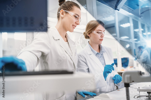 Canvastavla A team of laboratory technicians conduct a series of tests on a chemical analyzer in a biological laboratory