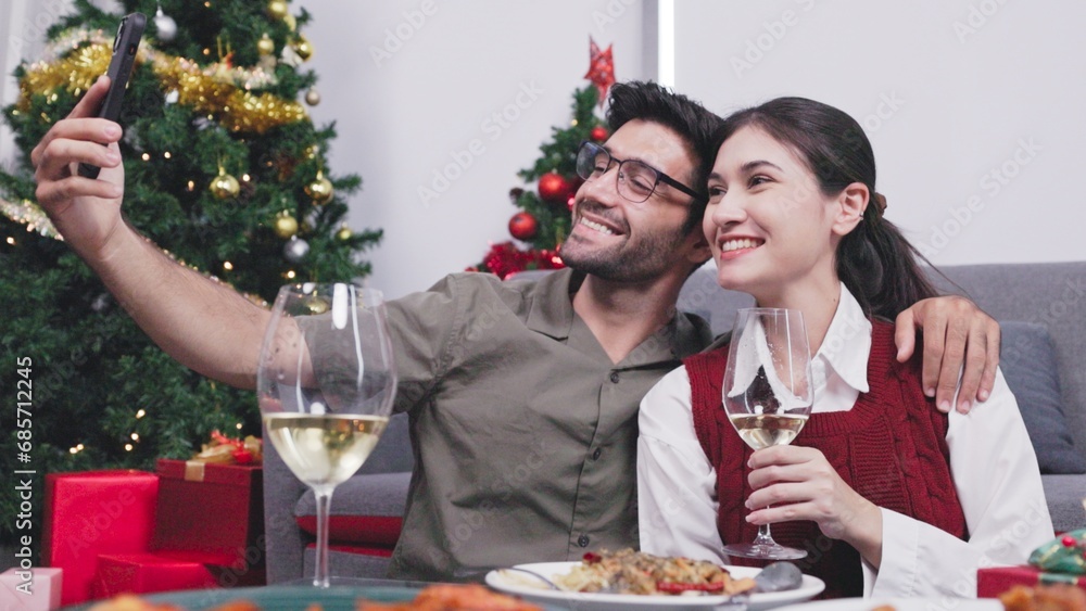 Happy young couple Video call with friends to celebrate Christmas at home Happy young couple Video call with friends to celebrate Christmas at home