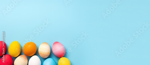 Colorful handcrafted Easter eggs on blue backdrop Minimalistic concept Top down perspective Text space on card Copy space image Place for adding text or design