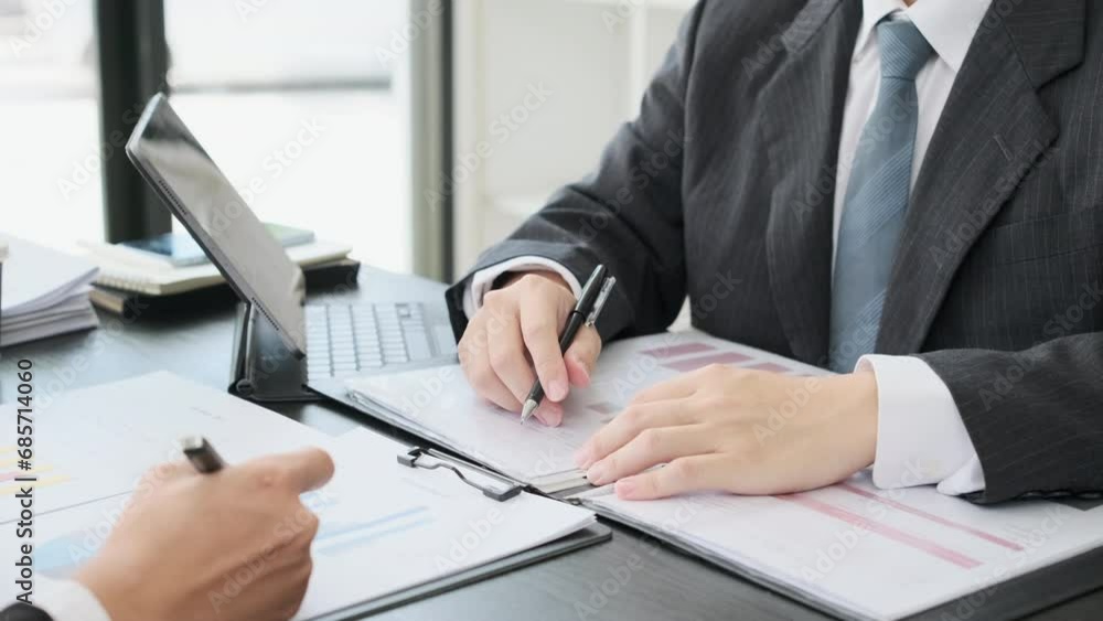 Slow motion closeup shot financial advisor pointing at reports, planning investment project with client Slow motion closeup shot financial advisor pointing at reports, planning investment project with client