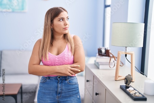 Young beautiful hispanic woman standing with arms crossed gesture at home