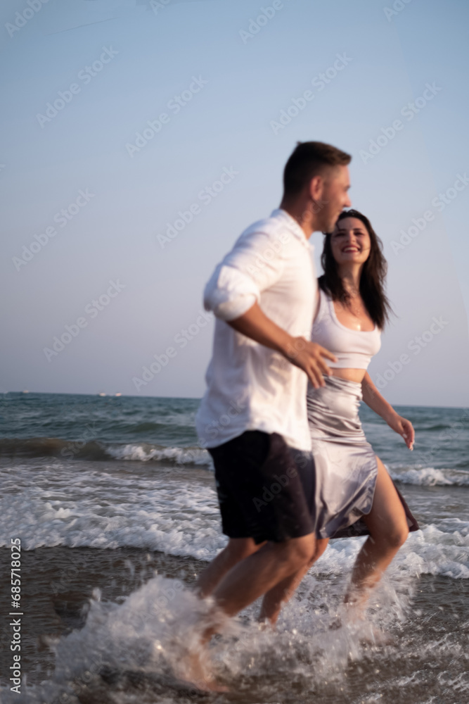 A man and a woman running along the seashore, Sunset scene. Couple in love, happy couple. Valentine's Day, sstkLOVE A man and a woman running along the seashore, Sunset scene. Couple in love, happy couple. Valentine's Day, sstkLOVE