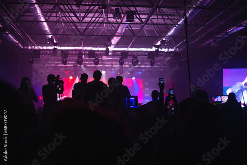 rock concert, music festival, New Year celebration, nightclub party, dance floor, disco club, many people standing with their hands up and clapping, happiness and nightlife concept