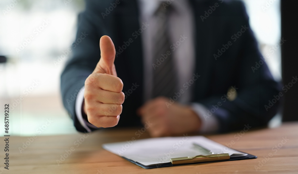 Businessman showing thumb up at work in office closeup. successful business people concept Businessman showing thumb up at work in office closeup. successful business people concept