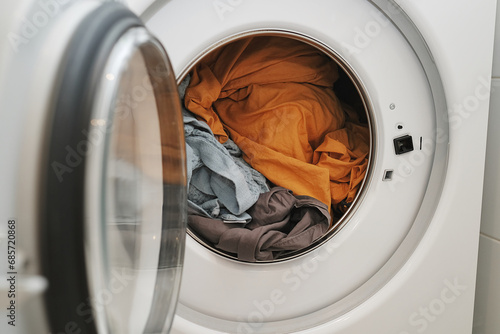 washing clothes. the drum of a white washing machine with home textiles inside. authentic photo