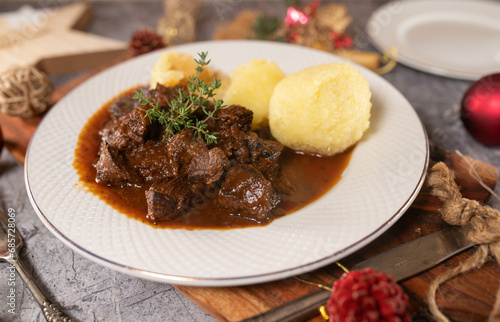 German beef goulash with potato dumplings on a plate for christmas dinner