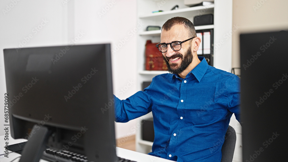 Young hispanic man business worker using computer with winner gesture at office Young hispanic man business worker using computer with winner gesture at office