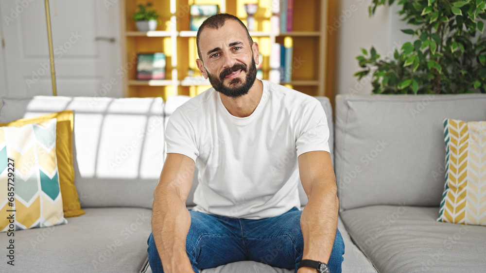 Young hispanic man smiling confident sitting on sofa at home Young hispanic man smiling confident sitting on sofa at home