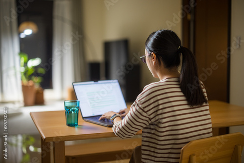Woman work form home with laptop in the evening