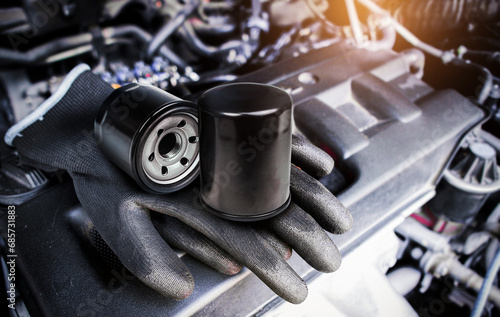 Engine oil filter and auto mechanic gloves on engine cover in a engine compartment for car engine maintenance , Car maintenance service concept