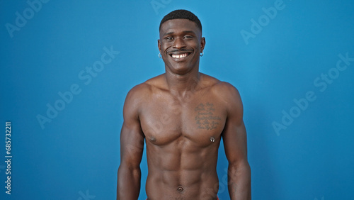 African american man smiling confident standing shirtless over isolated blue background