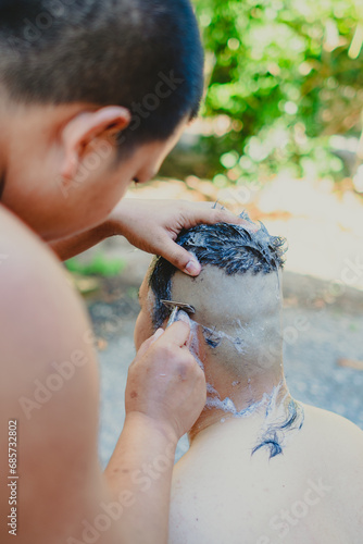 Monks shave their hair to become monks. Hair removal ceremony before ordination Hairdresser doing hair for a bald man Thai tradition