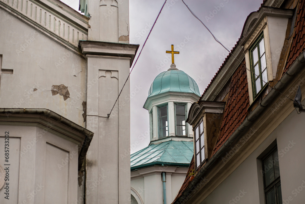 Gold christian cross shining in the top of a bright blue tower orthodox church in Latvia, Riga