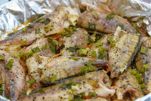 Fried or baked in foil river European perch in green onion