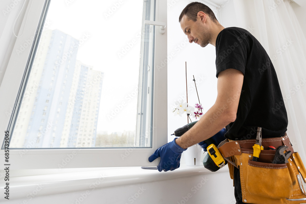 Worker in installing rubber seals on plastic upvc window. Worker in installing rubber seals on plastic upvc window.