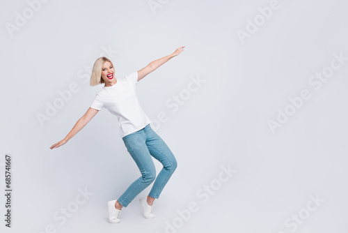 Full length photo of good mood nice girl with bob hair dressed white t-shirt hold arms like wings isolated on gray color background