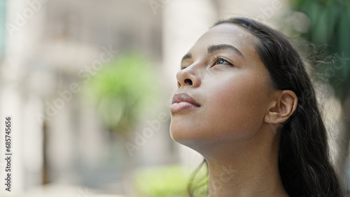 African american woman looking to the sky breathing at street