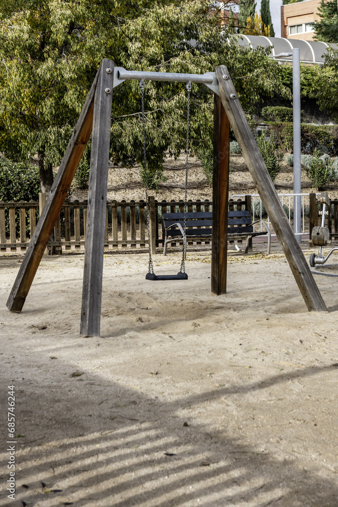 An urban playground with swings, slides and other games on a sandy floor An urban playground with swings, slides and other games on a sandy floor