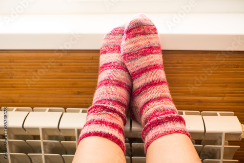Feet in warm winter socks warm up on the radiator.