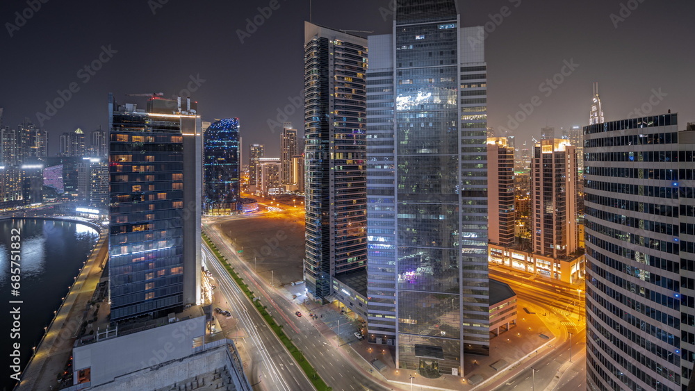 Panorama showing cityscape of skyscrapers in Dubai Business Bay with water canal aerial night timelapse