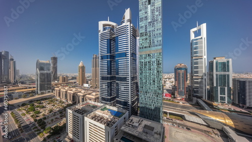 Aerial view of Dubai International Financial District with many skyscrapers all day timelapse.