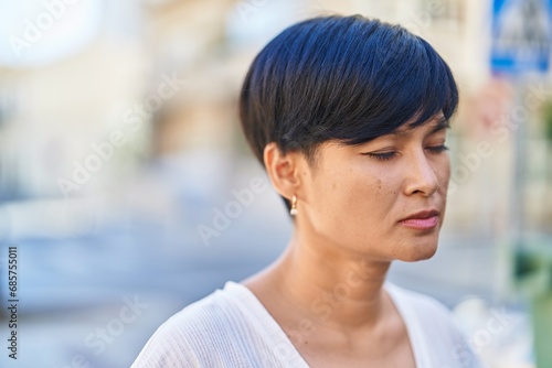 Middle age chinese woman breathing with closed eyes at street