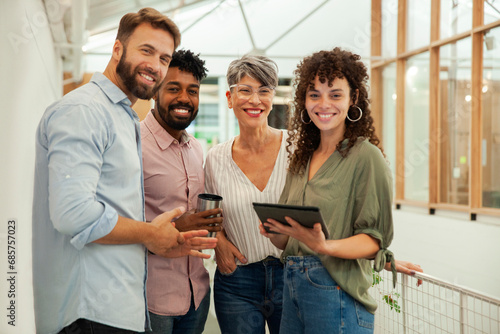 Group of coworkers looking at the camera while standing in hallway
