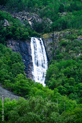Vertical realistic view of powerful waterfall falling from mountains in Norway