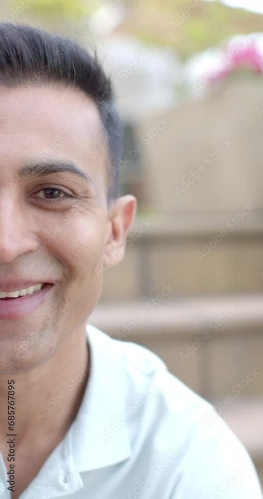 Vertical video half portrait of happy biracial man smiling in sunny garden, slow motion Vertical video half portrait of happy biracial man smiling in sunny garden, slow motion