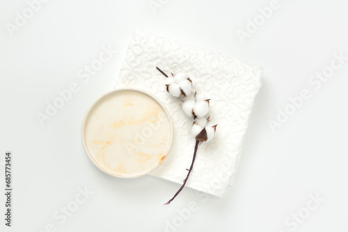 Beauty cosmetics product presentation flat lay scene made with mockup circle tray and cotton flowers branch on white towel.