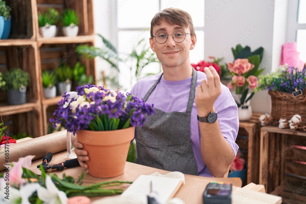 Caucasian blond man working at florist shop doing italian gesture with hand and fingers confident expression