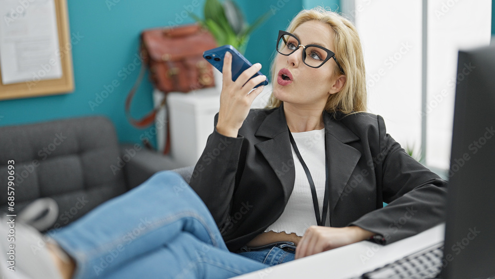 Young blonde woman business worker sending voice message by smartphone working at the office Young blonde woman business worker sending voice message by smartphone working at the office