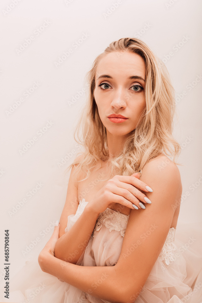 Beautiful woman in white dress on light background.Wedding day, bride's emotions Beautiful woman in white dress on light background.Wedding day, bride's emotions