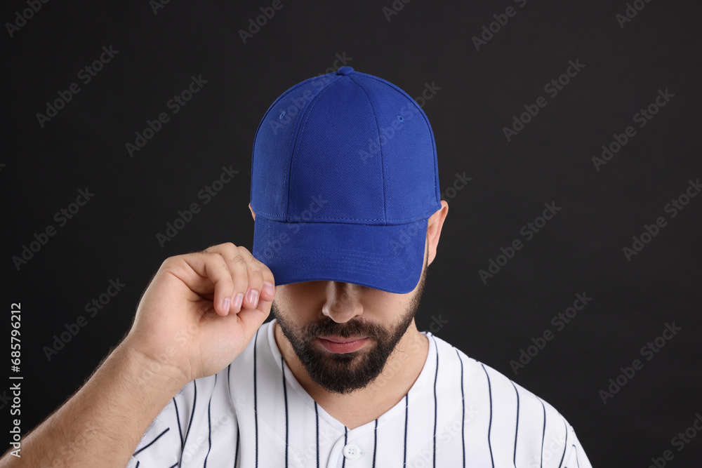 Man in stylish blue baseball cap on black background Man in stylish blue baseball cap on black background