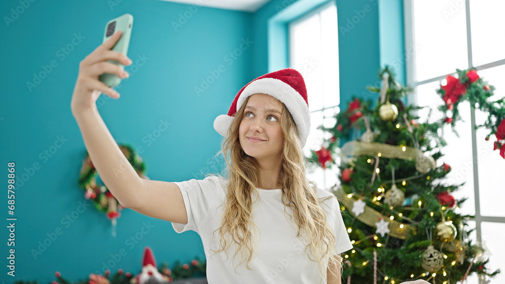 Young blonde woman make selfie by smartphone celebrating christmas at home Young blonde woman make selfie by smartphone celebrating christmas at home