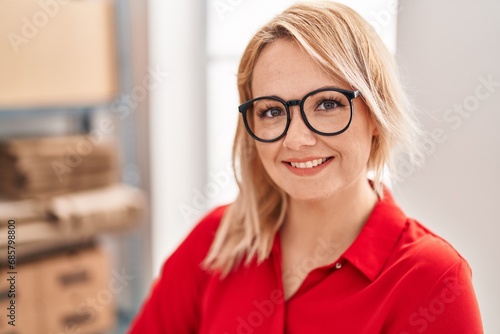 Young blonde woman ecommerce business worker smiling confident at office