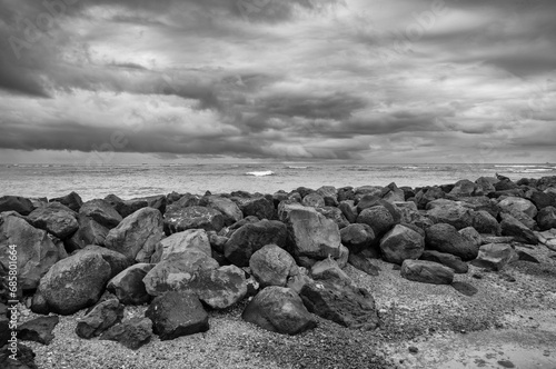 Dark Clouds over the Ocean with a Sea Wall in the Foreground.