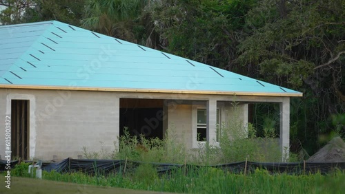 Rooftop covered with asphalt underlayment layer ready for installation of shingles on new house. Roof construction. Florida real estate development photo
