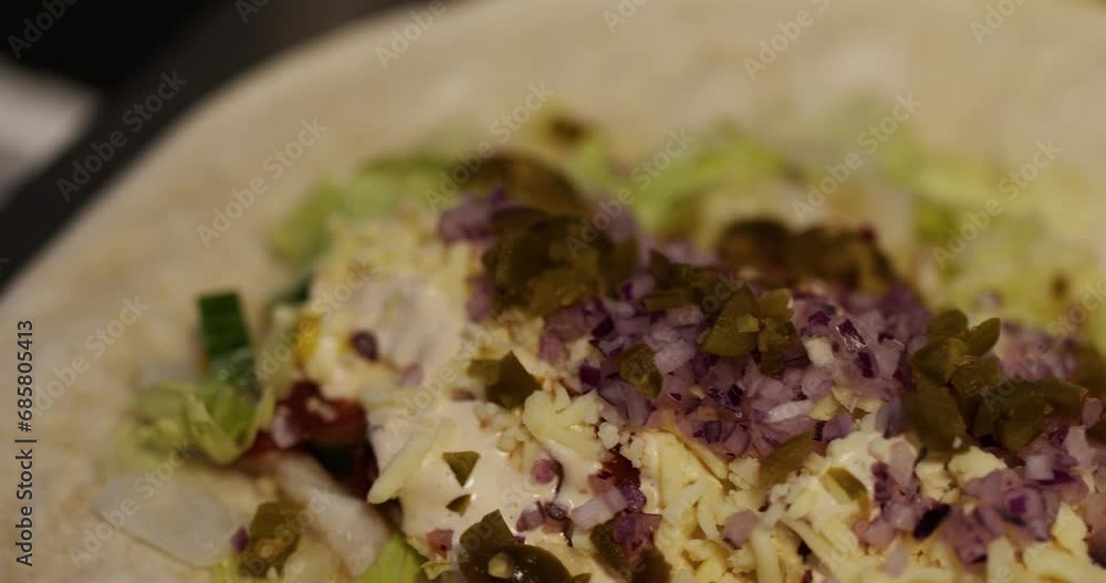 closeup of vegetables and jalapeños on burrito closeup of vegetables and jalapeños on burrito