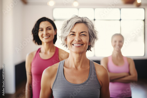 Confident smile middle aged woman in yoga studio with friends