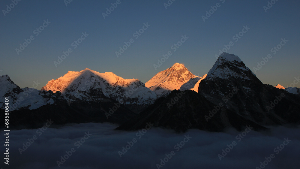 Bright lit Mt Everest at sunset, sea of fog, Nepal.